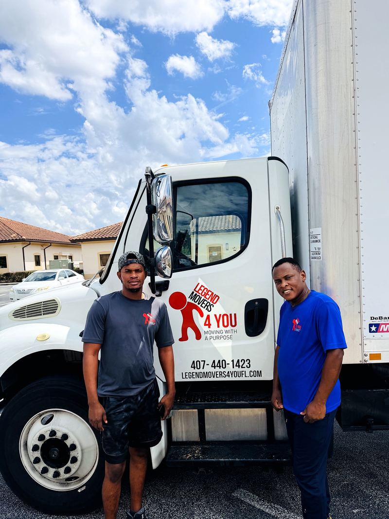 Two Legend Movers 4 You crew members beside the company truck