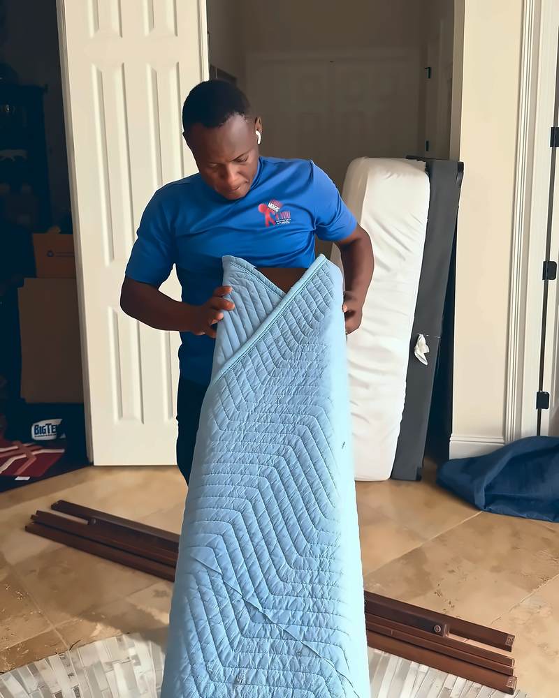 Legend Movers 4 You mover folding a moving blanket in a bedroom after a Central Florida move